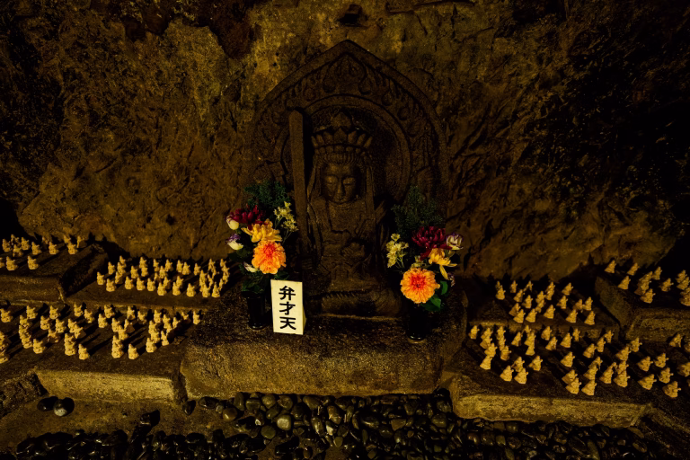 Small carved Buddhist figures lining the walls of the Benten-kutsu Caves in Kamakura