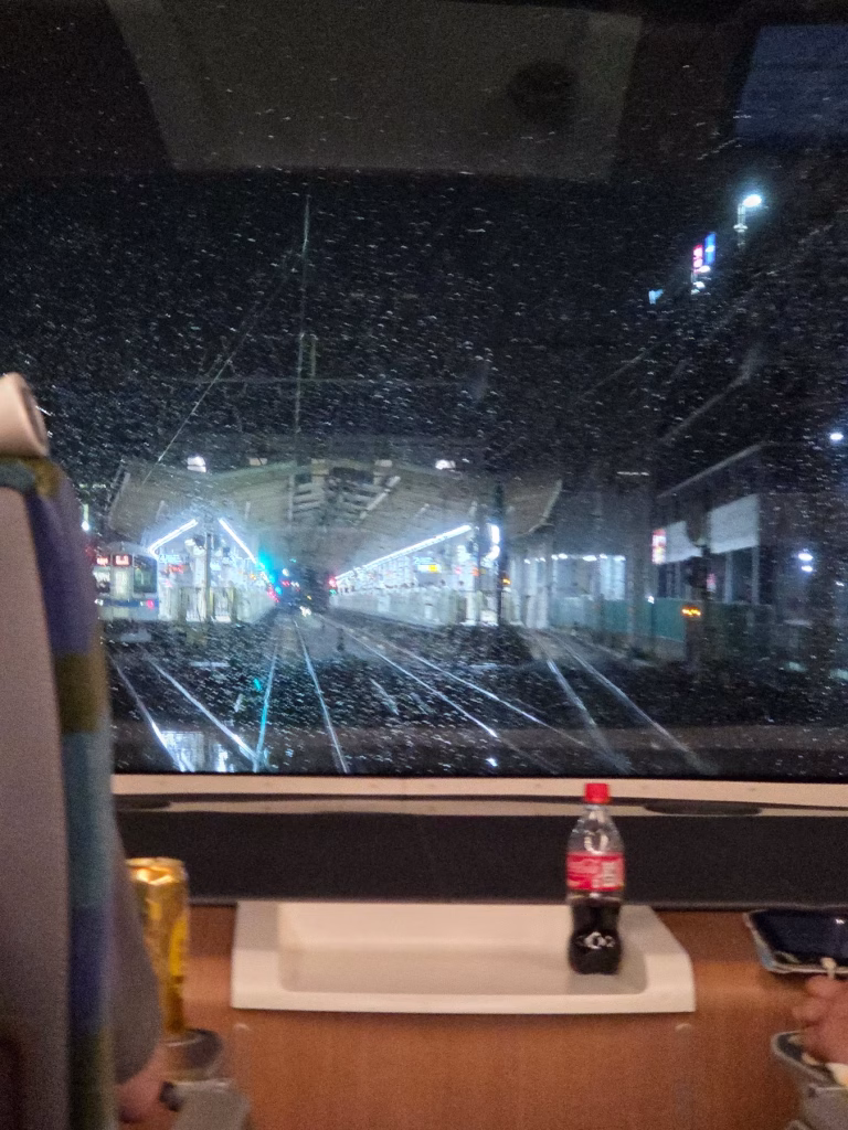 Interior of Romancecar train on a rainy night with seats and large windows on route to Tokyo from Hakone