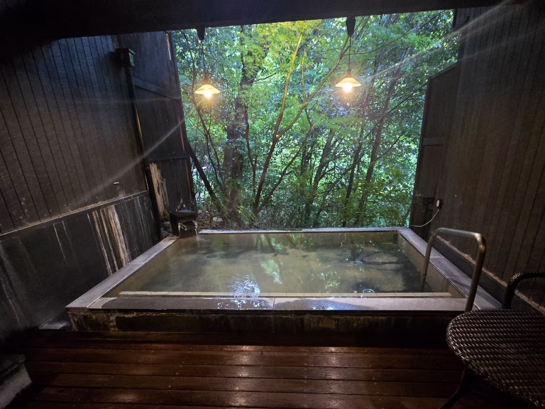 Outdoor onsen bath at Hakone Yuryo surrounded by mountains and forest in Hakone