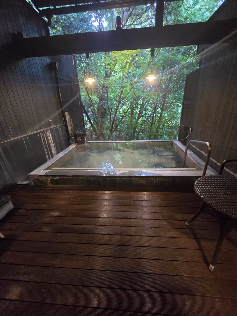 Outdoor onsen bath at Hakone Yuryo surrounded by mountains and forest in Hakone